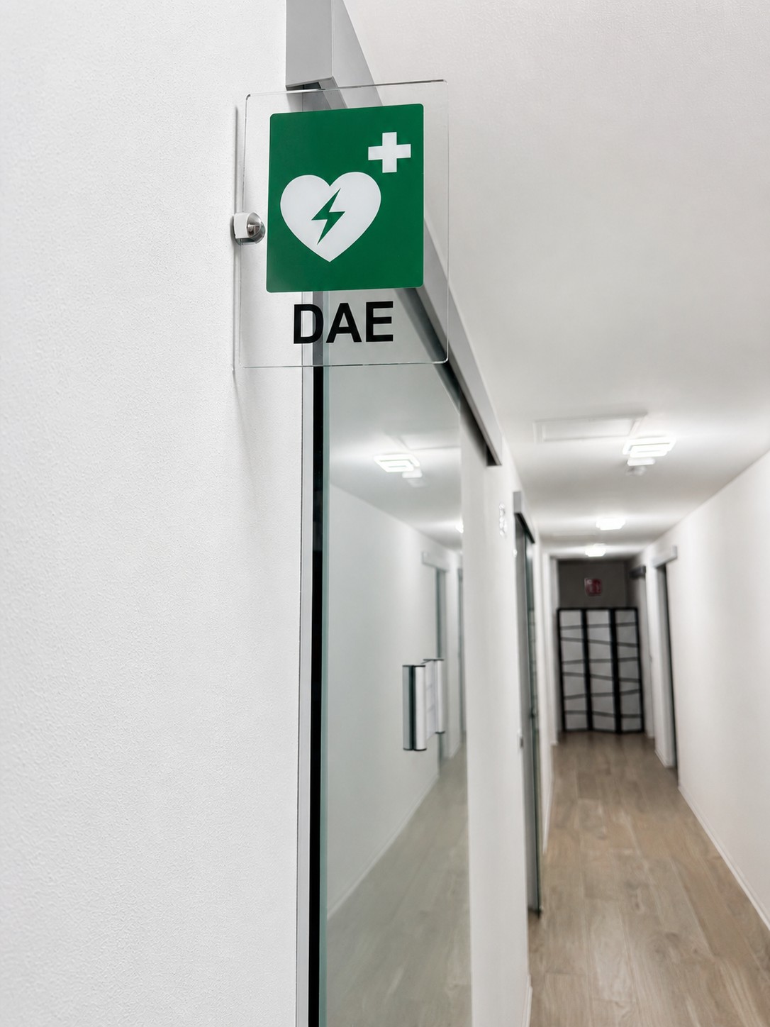 Cartello del defibrillatore DAE su una porta interna dello Studio Dentistico Lera