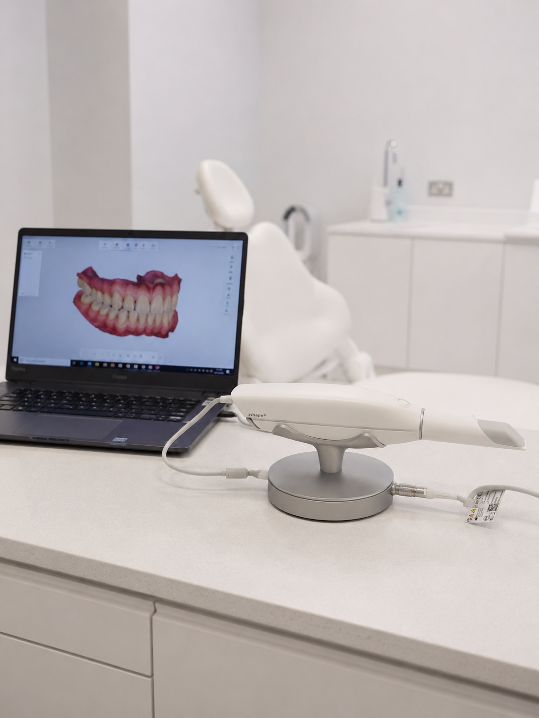 Scanner intraorale dello Studio Dentistico Lera sul banco, con il modello digitale dell’arcata sullo schermo del portatile